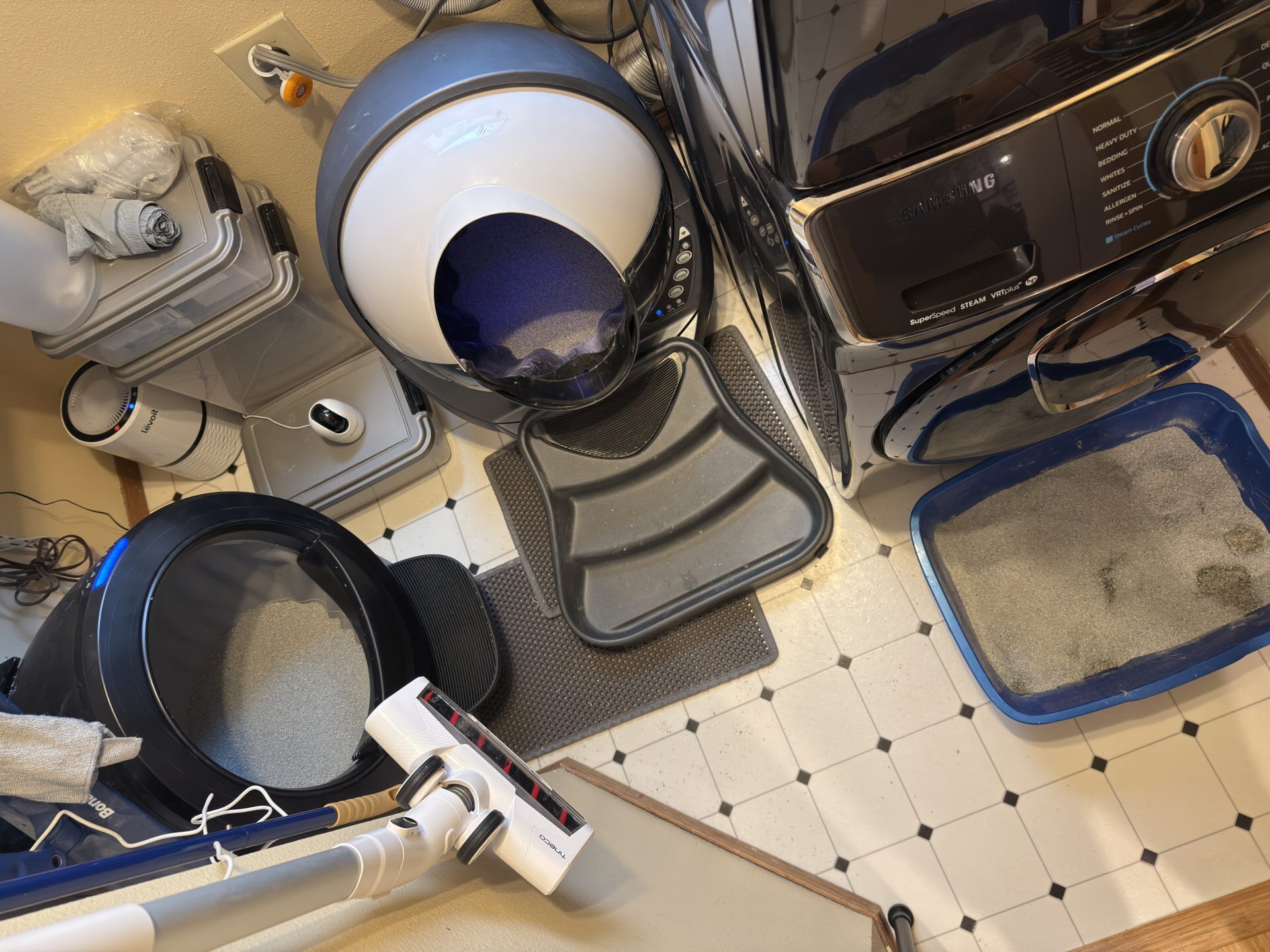 laundry room with two automatic litter boxes and a third traditional litter box